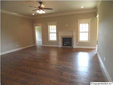 Family room with 10 foot ceilings, hand scrapped hard wood flooring, ceiling fan, recessed lighting, extensive trim, fireplace.