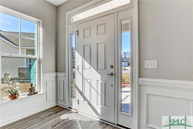 Roomy entry space with wainscoting greets you at t