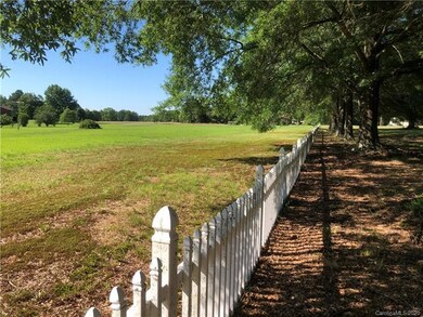 The lot extends several yards past this white fenc