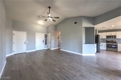 Unfurnished living room featuring a ceiling fan, h