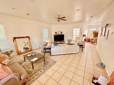 Living room featuring baseboards, light tile patt