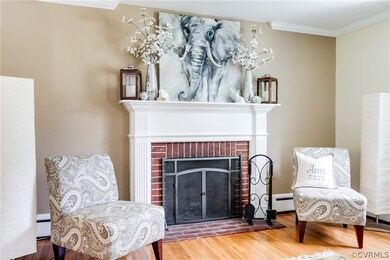The wood-burning fireplace has classic details with a brick hearth, white wood mantel, and fireplace screen.