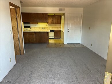 Kitchen with tile countertops, a sink, dark carpet