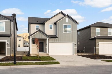 **DISCLAIMER - Exterior elevations may vary** View of front of property with board and batten siding, driveway, and an attached garage