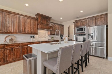 Kitchen featuring arched walkways, stainless appli