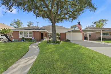 Beautiful single-story brick home with a well-maintained front yard featuring a large tree. Includes a covered carport and driveway, offering ample parking. The welcoming walkway leads to the front entrance. Perfect for comfortable living.