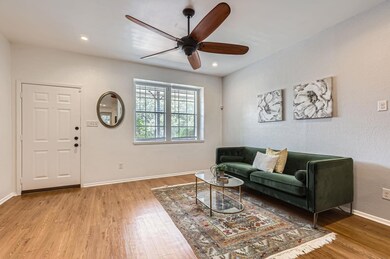 Living room with a ceiling fan, light wood-type f