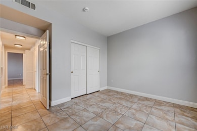 Unfurnished bedroom with light tile patterned floo
