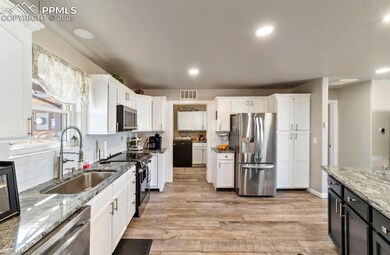 Kitchen featuring white cabinets, a sink, light wo