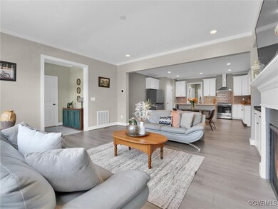 Living room with crown molding and light hardwood