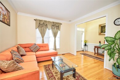 Living room with crown molding and wood-type floor