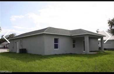 View of side of property featuring stucco siding, a yard, and a patio