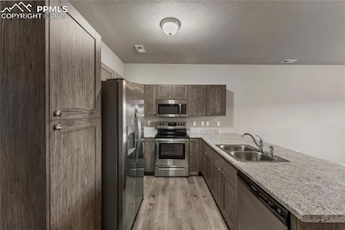 Kitchen with light countertops, a sink, light wood