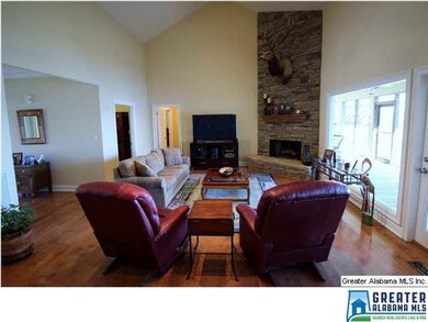 Soaring stone fireplace in great room has gas logs