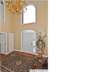 Foyer with arched window and brass chandelier