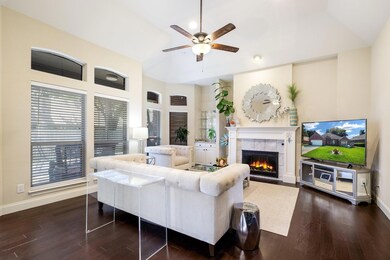 Living room featuring ceiling fan, a fireplace, an