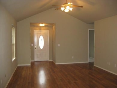 Foyer featuring a ceiling fan, wood finished floors, and lofted ceiling