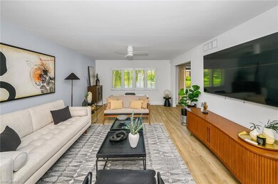 Living area with a ceiling fan, visible vents, and