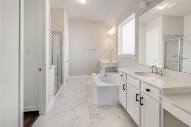 This primary bathroom is definitely move-in ready! Featuring a walk-in shower with tile surround, separate garden tub for soaking after a long day with custom tile detailing, white stained cabinets with light countertops, spacious walk-in closet with shelving, high ceilings, custom paint, sleek and dark modern finishes.
