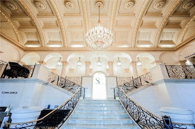 Stairs featuring a chandelier, crown molding, and a towering ceiling