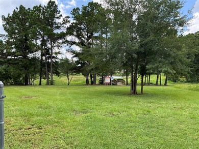 View of grassy yard featuring view of wooded area