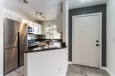 Kitchen featuring a textured ceiling, a sink, visi
