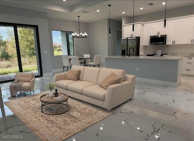 Living room featuring a chandelier, light marble f
