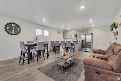 Living room with light wood-style flooring and recessed lighting