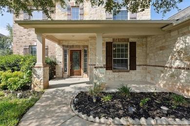 Property entrance featuring a porch and stone siding