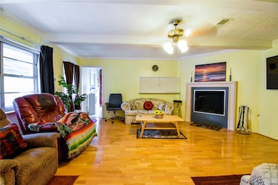 Cozy living room with gaslog fireplace and wood flooring