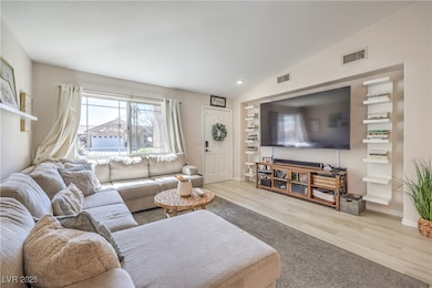 Living room featuring lofted ceiling, baseboards,