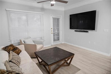 Living room with ceiling fan, crown molding, and light hardwood / wood-style floors