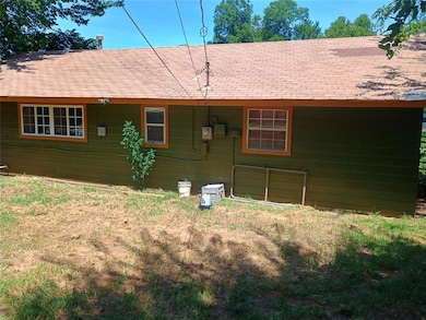 Back of house featuring roof with shingles