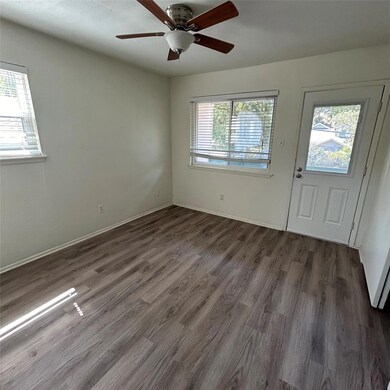 Foyer with dark wood-style floors, baseboards, an