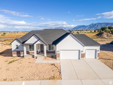 View of front of property featuring covered porch, brick siding, concrete driveway, a mountain view, and an attached garage