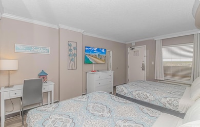 Bedroom with light wood-type flooring, a textured 