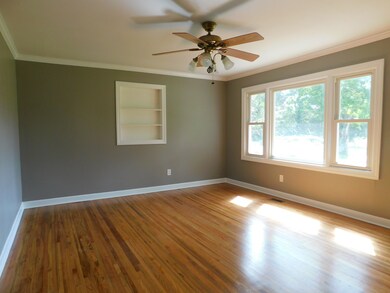 A ceiling fan and crown molding highlight the living room. 