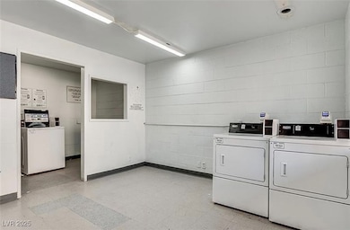 Community laundry room featuring concrete block wa