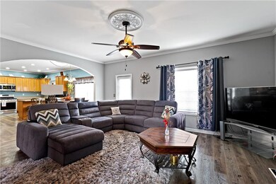 Living area with crown molding, wood finished floo