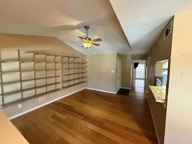 Unfurnished living room featuring ceiling fan, dar