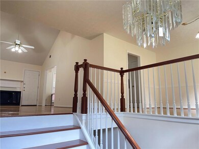 Stairway featuring ceiling fan, a textured ceiling, and high vaulted ceiling