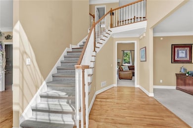 Staircase featuring ornamental molding, wood finis