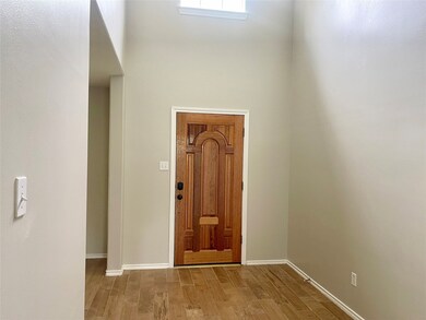 This photo shows a bright entryway with high ceili