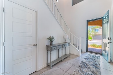 Foyer with stairs, light tile patterned floors, an