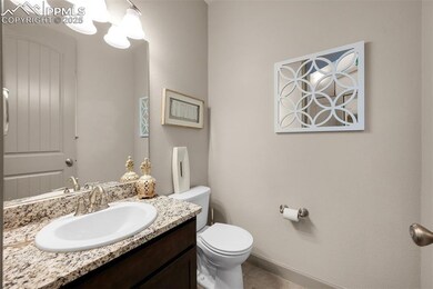 Half bathroom featuring toilet, vanity, and tile patterned flooring