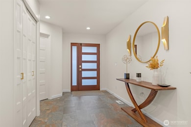 The wide entryway creates an inviting sense of space, enhanced by a custom-made front door. Smart locks on both the front and side doors provide keyless, secure entry and convenient remote access.