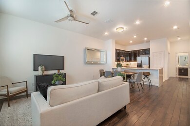 Main level living room featuring dark wood floors, recessed lighting, and a ceiling fan