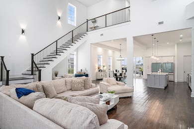 Living area featuring a towering ceiling, stairway