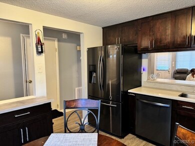 Kitchen featuring a textured ceiling, light hardwo