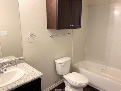 Bathroom with toilet, baseboards, shower / tub com